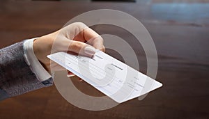 Hand giving paycheck, check, cheque