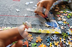 Hand giving support by giving a piece of puzzle, connecting jigsaw together. Group project concept. success and strategy and