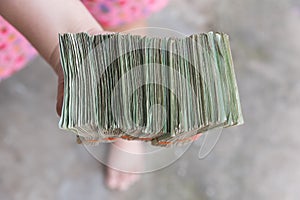 Hand giving Thai banknotes