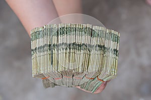 Hand giving Thai banknotes