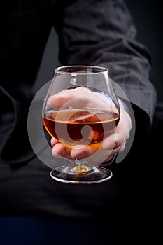 Hand with glass of cognac
