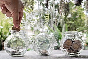 Hand and Glass jar piggy bank with coins. Plan your savings, run a growing business for success and save for retirement