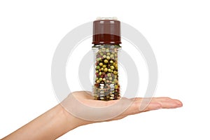 Hand with glass pepper mill isolated on white background, hot and spicy flavor