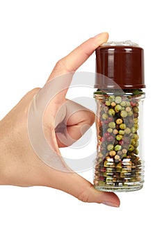 Hand with glass pepper mill isolated on white background, hot and spicy flavor