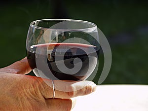 Hand with glass of red wine