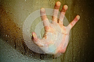 Hand on glass shower door