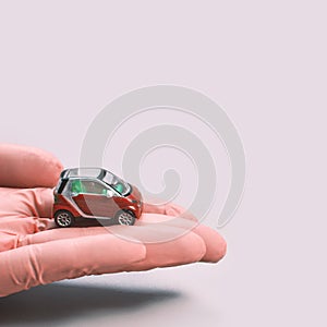 Hand in glove defend toy car. Safety insurance concept