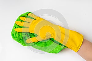 Hand in glove with green rag is wiping white door in kitchen