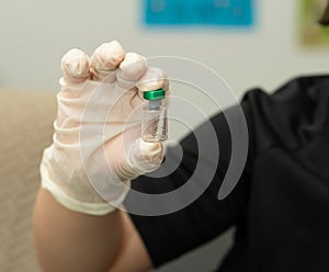 Hand in glove hold empty vial in lab