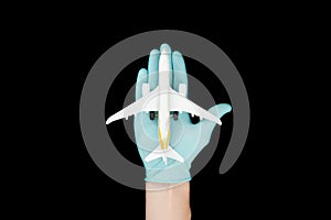 Hand in glove holding model airplanes on black background. Concept traveling. Copy space