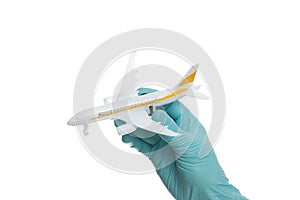 Hand in glove holding model airplanes on white background. Concept traveling. Copy space