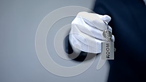 Hand in glove showing keychain with Room word, luxury rental housing service