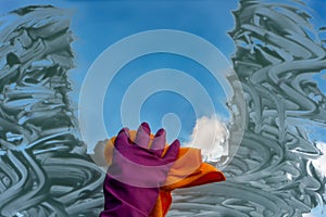 A hand in a glove washes the window