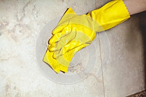 Hand in glove wipes tile with rag