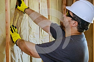 Hand in gloves holding mineral wool, building under construction wall insulation with rock wool