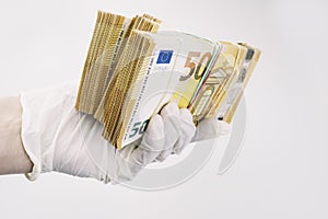 hand with gloves receiving, giving or holding euro cash banknote