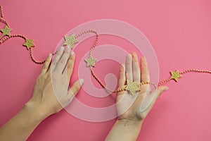 hand with golden bracelet star on a pink backgroun