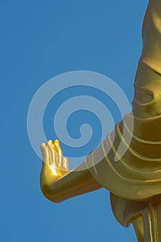 Hand of golden buddha statue with blue sky background