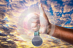 A hand and A golden medal.