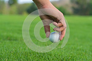 Hand Golfer hold Golf ball with tee ready to be shot at golf court