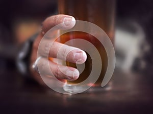 Hand grabbing glass of beer