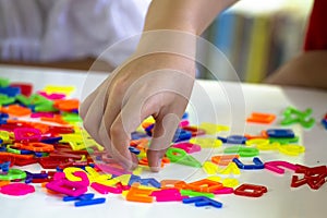Hand grabbing the plastic letters