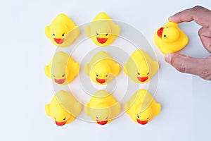 Hand grabs toy duck from the group of workers. Firing someone concept
