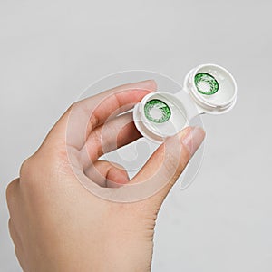 Hand and green contact lens pair in box / day ACUVUE