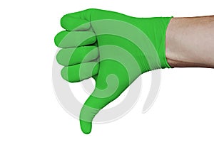 Hand in green medical glove showing disapproval thumbs down sign isolated on white background