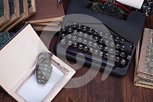 Hand grenade hidden in a book with old retro typewriter