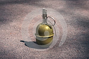 Hand grenade RGD-5 on asphalt. abandoned lost pomegranate green on the pavement. fragmentation grenade photo