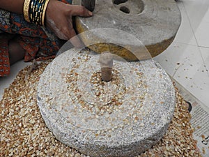 Hand grinding cow peas with millstone in Indian house