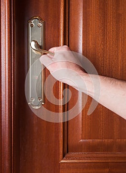 Hand gripping the handle of a door