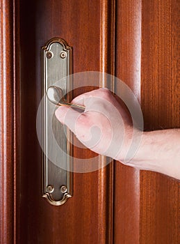 Hand gripping the handle of a door