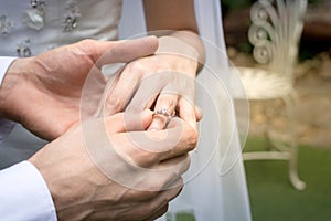 Hand of the groom wears a wedding ring bride