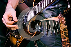 Hand of a guitarist plays live music on his electrical solo guitar, cool hard rock