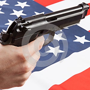 Hand gun over ruffled national flag - United States