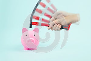 Hand hammer smashes piggy bank with savings. Concept of financial crisis