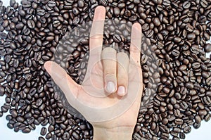 The hand Hand in rock n roll sign and coffee beans