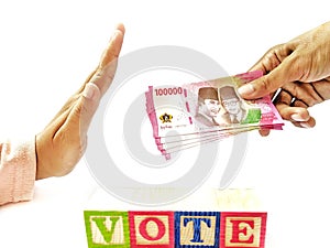 The hand that handed over 100,000 rupiah and the other hand gestured to reject it. Underneath is the word VOTE photo