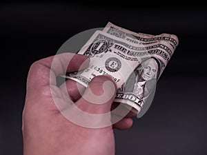 Hand handing over money in hand. US dollar USD bills. Concept of giving