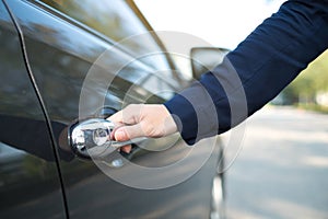 Hand on handle. Close-up of female hand opening a car door