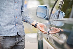 Hand on handle. Close-up of man opening a car door.