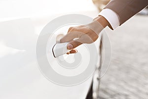 Hand on handle. Male hand in formalwear opening car door