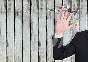 Hand with hands with tools on the fingers. Wood background