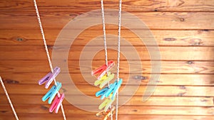 Hand hanging colorful clothespins on the clothesline for drying clothes on the balcony