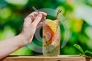 Hand with hard seltzer cocktail.