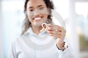 Hand, hearing aid and insurance with a black woman holding a listening device in a healthcare clinic. Medical