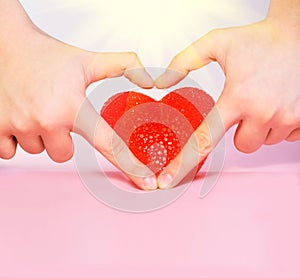 Hand heart and red heart shape.Pink background.Sun rays.Sunshine.Copy space for text