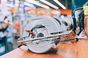 A hand-held cutting saw on a shelf with tools